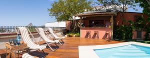 a wooden deck with chairs and a swimming pool at Gerthrudes Bed & Breakfast in Rio de Janeiro
