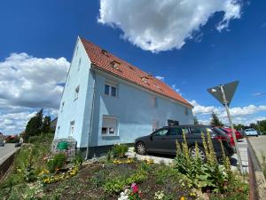 a white house with a car parked next to it at Wanderlust in Bisingen