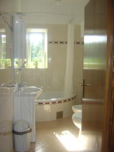 a bathroom with two sinks and a tub and a toilet at Villa Korčula in Korčula