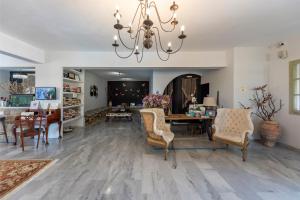 a living room with a table and chairs and a chandelier at Parosland Hotel in Aliki