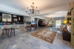 a living room with a bar and a dining room at Parosland Hotel in Aliki
