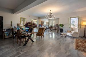 a large living room with a table and chairs at Parosland Hotel in Aliki
