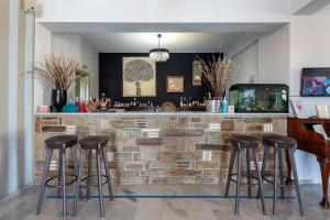 a bar with stools in front of a brick wall at Parosland Hotel in Aliki