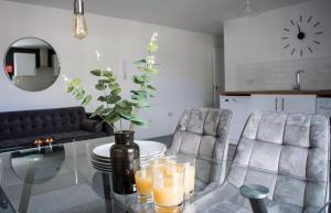 a glass table with a vase and two chairs at Golden Key Apartments in Lillington