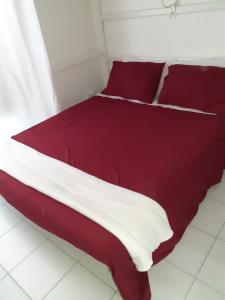 Bett mit roter und weißer Bettwäsche und Kissen in der Unterkunft Piccola Montmartre a Torino in Turin