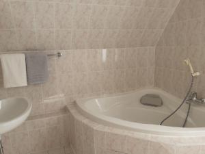 a bathroom with a bath tub and a sink at Villa Tannerhof in Braunlage