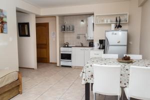 a kitchen with a table and white appliances at DEPARTAMENTO CON EXCELENTE UBICACIÓN in San Carlos de Bariloche