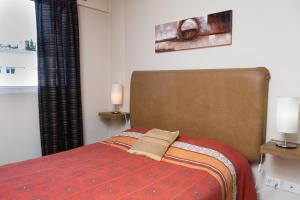 1 dormitorio con 1 cama con manta roja y 2 lámparas en DEPARTAMENTO CON EXCELENTE UBICACIÓN en San Carlos de Bariloche
