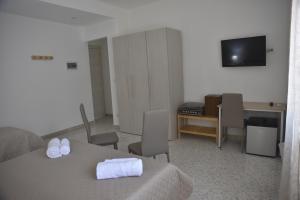 a hotel room with a bed and a desk and a television at B&B Stella in Catania