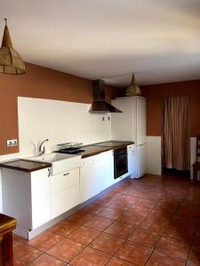 a kitchen with white cabinets and a tile floor at Hoz de Jaca, Casa Mas Mañanas. in Hoz de Jaca