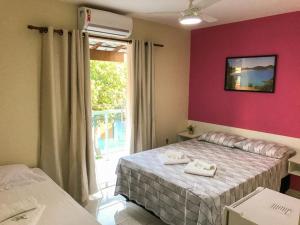 ein Hotelzimmer mit 2 Betten und einem Fenster in der Unterkunft Pousada Caminho dos Anjos in Arraial do Cabo