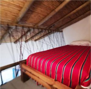 a red and black striped bed in a room at Hostel Once Once in Villa de Leyva