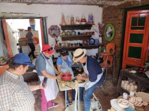 a group of people in a kitchen preparing food at Hostel Once Once in Villa de Leyva