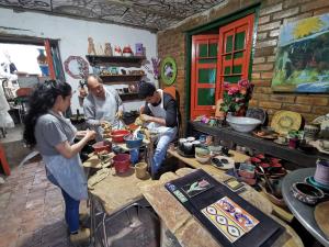 a group of people in a room preparing pottery at Hostel Once Once in Villa de Leyva