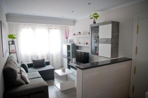 a living room with a couch and a television at Zubia Home Portugalete - Impecable- 3 min metro Bilbao in Portugalete