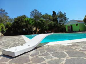 un tobogán blanco junto a una piscina en Il Melograno, en Campanedda