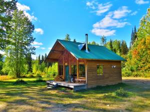 una cabaña en el bosque con techo verde en Rocky Ridge Resort-BC en Smithers