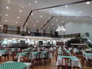 a dining room with tables and chairs and a chandelier at Hotel Recanto das Hortênsias in Passa Quatro
