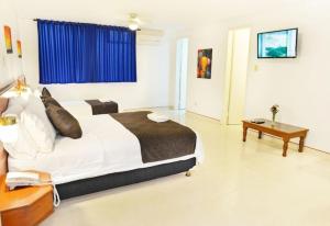 a bedroom with a large bed and a table at Hotel Thama in Palmira