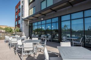 a group of tables and chairs in front of a building at Holiday Inn Express & Suites - Phoenix North - Happy Valley, an IHG Hotel in Phoenix