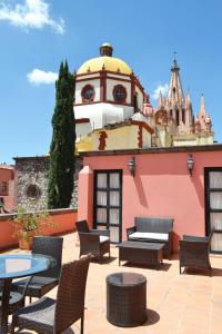 a patio with chairs and tables and a building at Hotel Casa Rosada - Adults Only in San Miguel de Allende