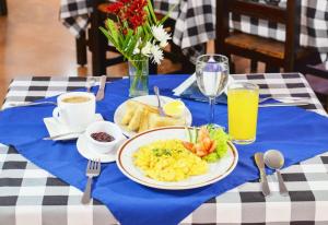 a table with a plate of breakfast food on a blue table cloth at Hotel Thama in Palmira