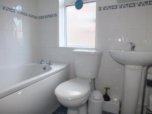 een witte badkamer met een toilet en een wastafel bij Stamford Place by SG Property Group in Crewe