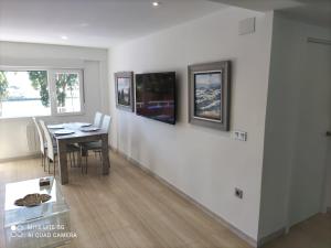 a dining room with a table with chairs and paintings on the wall at Playa del Puntal Villaviciosa Asturias Lujo Primera Linea Playa in Villaviciosa