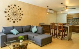 a living room with a couch and a table and a kitchen at Albra Tulum in Tulum