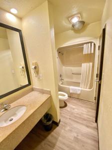 a bathroom with a sink and a toilet and a mirror at Travelers Inn Elizabeth City in Elizabeth City