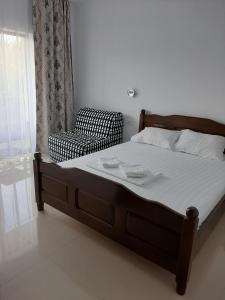 a bedroom with a bed and a chair and a window at ROMSIL CASA VACANTA in Costinesti +15 photos
