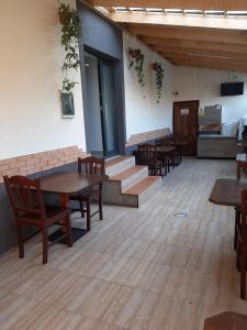 a restaurant with wooden tables and chairs and stairs at ROMSIL CASA VACANTA in Costinesti