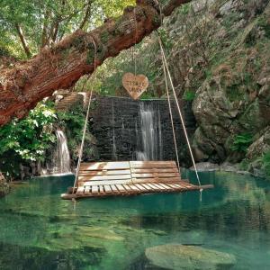 a swing in a river with a waterfall at Casa Catraia Gondramaz no Pulmão da Serra da Lousã in Gondramaz
