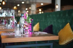 a table in a restaurant with wine glasses and flowers at DIWOTEL by Trip Inn Frankfurt Airport Dreieich in Dreieich