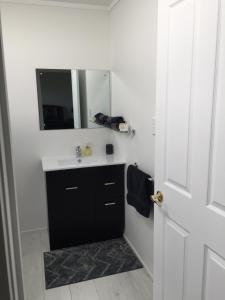 a bathroom with a sink and a mirror at A Cut Above Lodge - The Gateway to the Bay of Islands in Kerikeri +25 photos