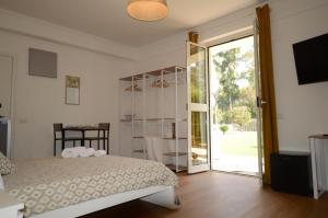 een slaapkamer met een bed en een glazen schuifdeur bij CASA BLANCA in Latina