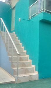 a blue building with stairs next to a blue wall at Apartamentos no Farol Velho in Salinópolis