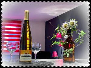 - une bouteille de vin et deux verres sur une table dans l'établissement Résidence des lentilles, à Schiltigheim