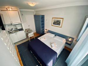a small room with a bed and a kitchen at Komiza Provita Guesthouse in Komiža