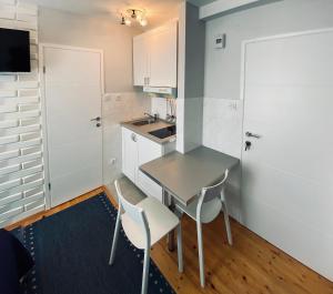 a small kitchen with a table and chairs at Komiza Provita Guesthouse in Komiža