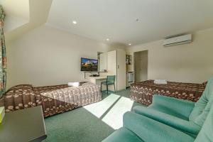una camera d'albergo con letto e divano di Legends Motel a Palmerston North