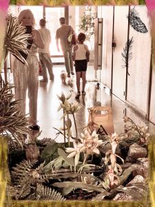 a group of people walking down a hallway with plants at Square du Château in Schiltigheim