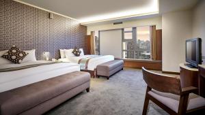 a hotel room with two beds and a television at Zhong Ke Hotel in Taichung