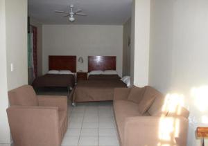 - un salon avec un canapé et un lit dans l'établissement Hotel Gina, à San Juan de los Lagos