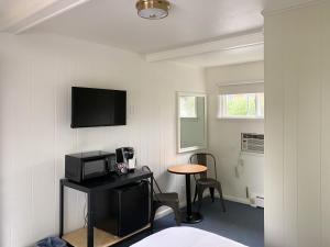 a room with a microwave and a table with a television at The River Hills Motel - Algoma, WI - Near Door County in Algoma