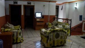 ein Wohnzimmer mit 2 Betten und einem TV in der Unterkunft Hotel Senorial in San Juan de los Lagos