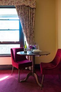 una sala da pranzo con tavolo, due sedie e una finestra di Merrijig Inn a Port Fairy