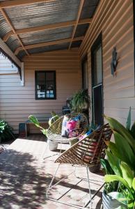 un patio con mesa y sillas en un porche en Merrijig Inn en Port Fairy