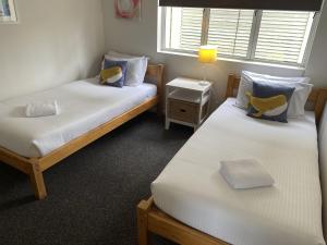 two twin beds in a room with a window at Aqua Promenade Beachfront Holiday Apartments in Sunrise Beach