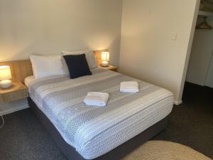a bedroom with a bed with two towels on it at Aqua Promenade Beachfront Holiday Apartments in Sunrise Beach